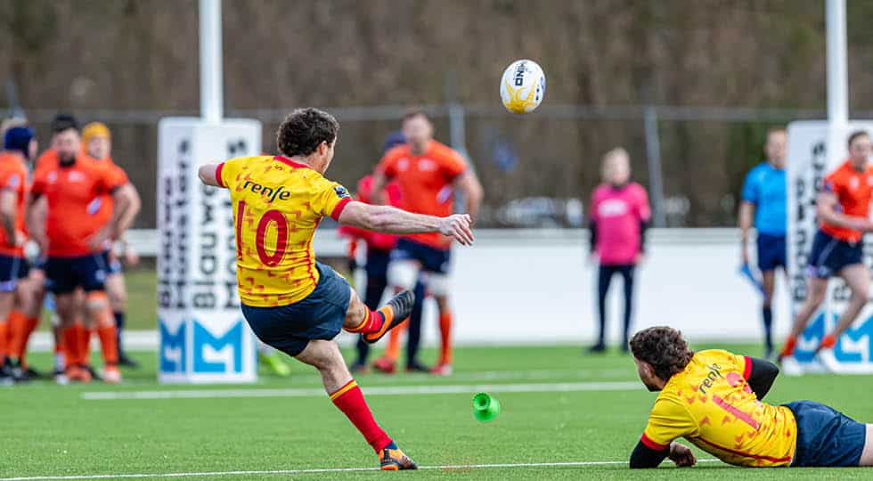 Un joueur de rugby tape une pénalité en bottant un ballon RHINO