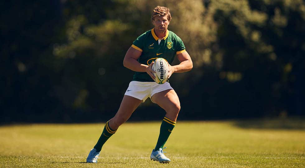 Un joueur des Springboks en pleine course sur un terrain de rugby portant un ballon Vortex Pro